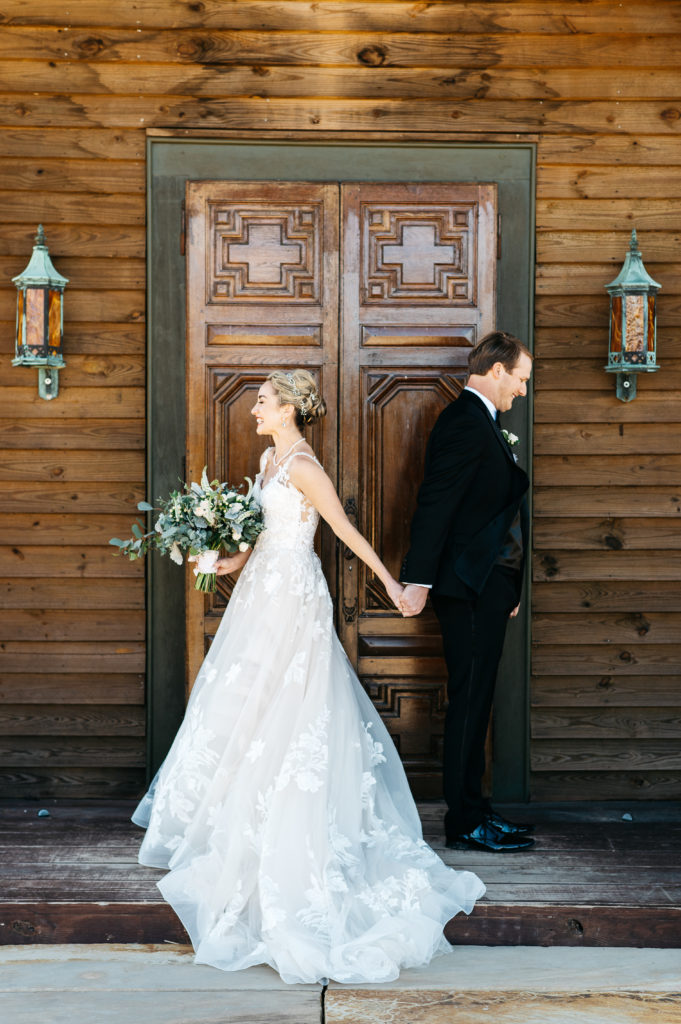 bride and groom hold hands before first look in front of chapel - aiken, sc wedding photographer