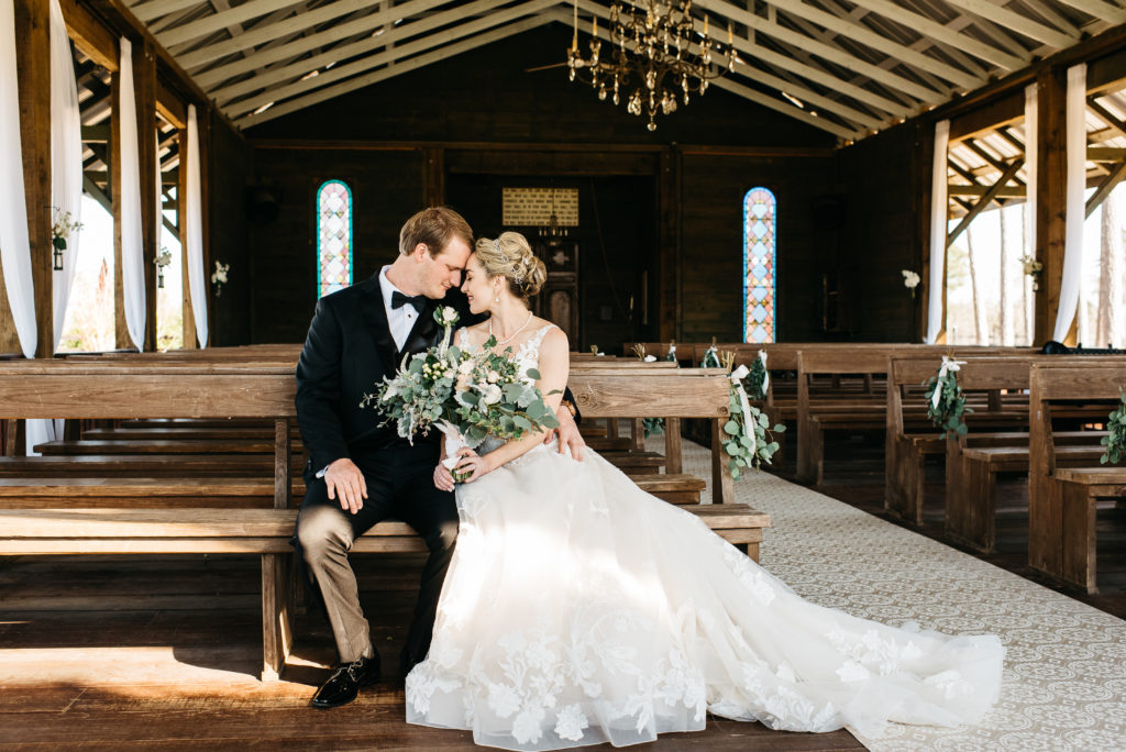 bride and groom sitting in the chapel at pine knoll farms appling, ga ---aiken, sc wedding photographer 